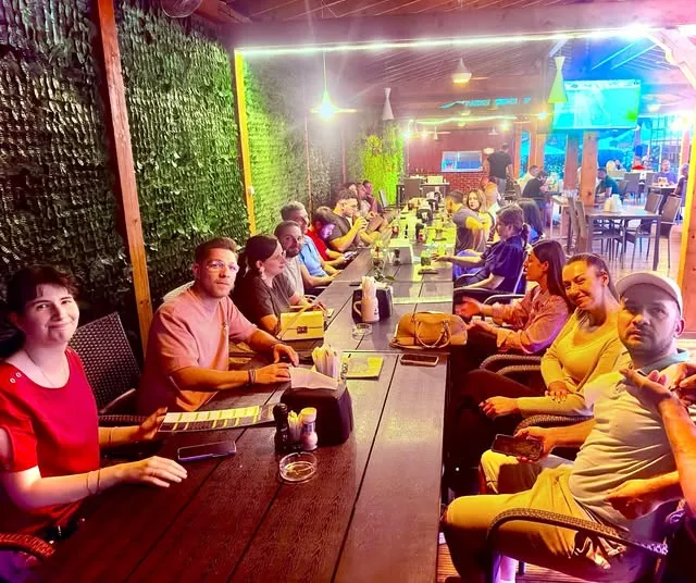 Seară la restaurant cu membrii comunității Gatherings, pe o terasă iluminată colorat